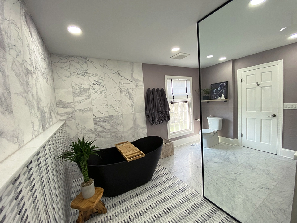 A stunning bathroom renovation featuring a large mirror and a luxurious tub, crafted by expert team.